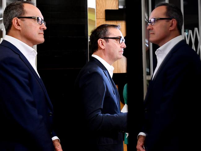 South Australian Liberal leader Steven Marshall (centre) and Liberal frontbencher Corey Wingard are seen reflected in a shopfront during a press conference at Marion Shopping Centre in Marion, Monday, March 12, 2018. Opposition Leader Steven Marshall says he'll move swiftly to deregulate shop trading hours in South Australia if the Liberals win Saturday's election. (AAP Image/Tracey Nearmy) NO ARCHIVING