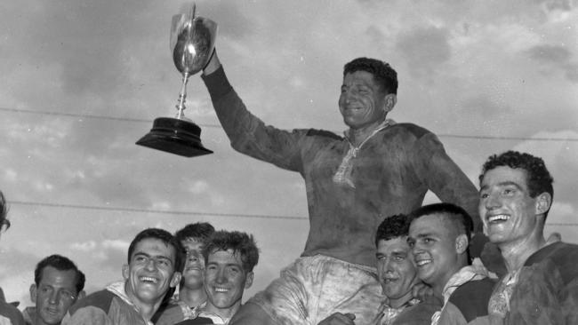 Norths rugby league captain Bill Pearson waves the 1960 BRL Premiership Cup as he is chaired off the field by teammates from left; Norm Hynes, Greg Fowler, Barry Stevens and Harry Bates after Norths won the Grand Final at Lang Park (Pic Jim Fenwick)