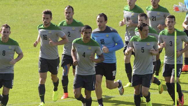 Socceroos' players led by vice captain Tim Cahill warm up during a training session.