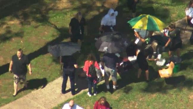 A student lays on the ground while staff and paramedics surround him. Picture 7 News.