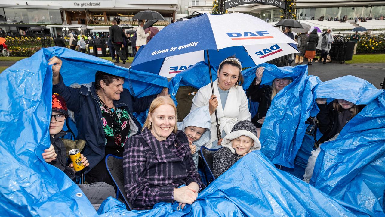 The Newitt family uses a tarp too shelter from the rain. Picture: Jake Nowakowski