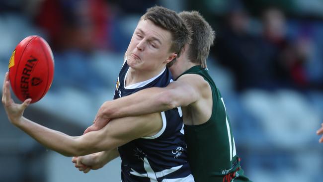 Ballarat’s Jed Hill tries to control the ball as he is tackled by Hampden’s Hamish Sinnott. Picture Yuri Kouzmin