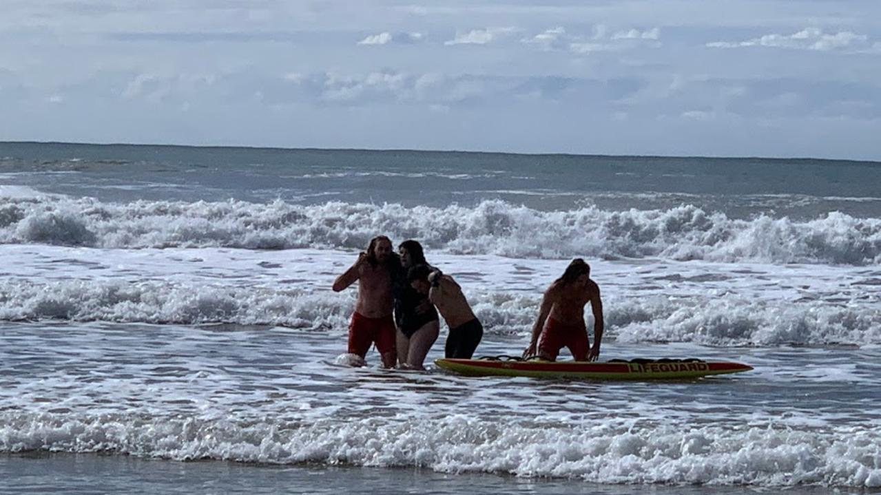 Surf Life Saving Queensland lifeguards rescue a woman and boy from rough surf at Alexandra Headland on Sunday morning. Picture: Stuart Cumming