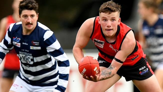 Samuel Wilson of Romsey handballs during the round 16 Riddell District Football Netball League 2023 Bendigo Bank Seniors match between Romsey and Macedon at Romsey Park in Romsey, Victoria on August 5, 2023. (Photo by Josh Chadwick)