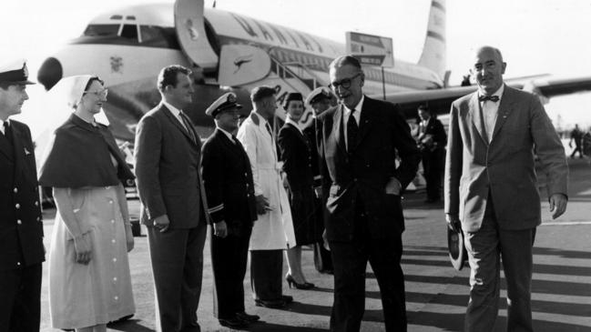 Sir Hudson Fysh (walking, on left) and Boeing Company present William Allen walk through a guard of honour representing every department in Qantas at the end of the first delivery flight from the US of Qantas's first Boeing 707 aircraft at Sydney Airport in 1959.