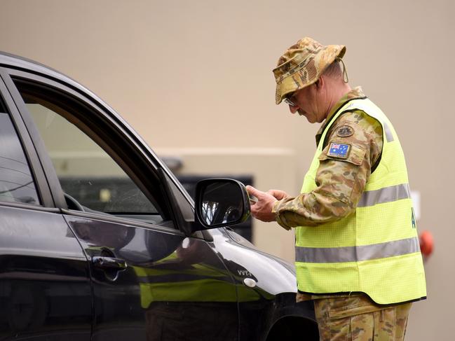 Australian Defence Force personnel help police check cars at the Queensland border with NSW on Griffith Street in Coolangatta on Wednesday. Picture: Steve Holland