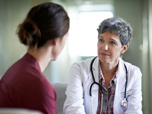 Shot of a compassionate doctor comforting a young woman in a hospital waiting room; fear health scare generic