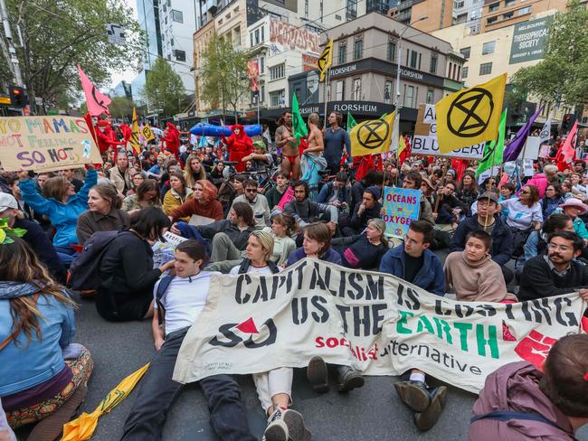 Demonstrators stage a sit-in on a road during a Extinction Rebellion protest in Melbourne on October 7, 2019. - Extinction Rebellion activists began gathering in cities across Australia and New Zealand on October 7 to kick off a fortnight of global civil disobedience demanding governments take urgent action on climate change. (Photo by ASANKA BRENDON RATNAYAKE / AFP)