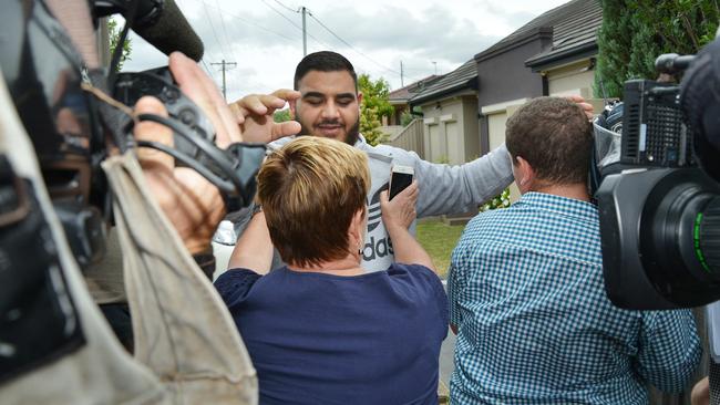 A man pushes media back at the house where Tongan Same was shot as guests arrive Saturday’s wedding. Picture: Troy Snook