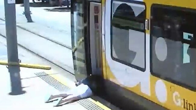 A person lies on the ground after falling while rushing to board a tram which was about to depart. Picture: GoldlinQ