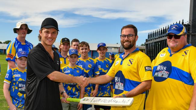 Adam Zampa presents a bat to Lismore Marist Brothers Cricket Club president Matt Cleaver and secretary Glen Lees.