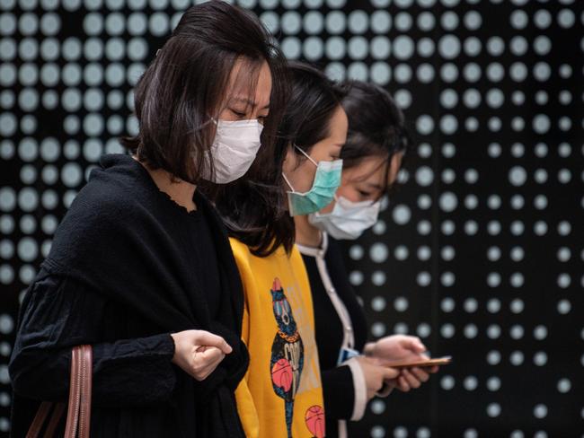 Three women walk together wearing protective face masks in Sydney, Monday, March 16, 2020. (AAP Image/James Gourley) NO ARCHIVING