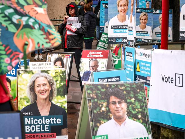 Volunteers hand out voting cards next to election candidate posters outside a pre-polling centre in Sydney on May 2, 2025, ahead of Australiaâs federal election scheduled for May 3. (Photo by DAVID GRAY / AFP)