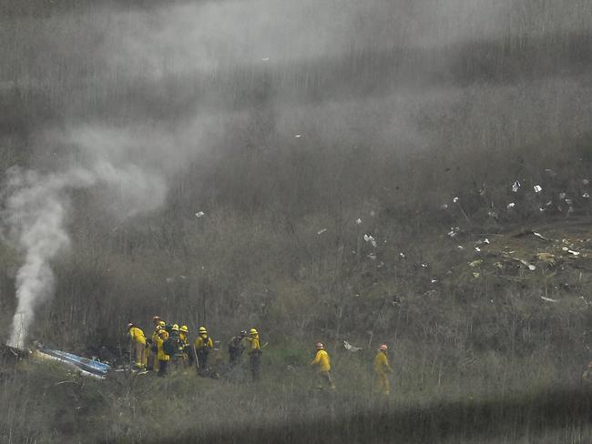 Firefighters work the scene of the helicopter crash. Picture: AP