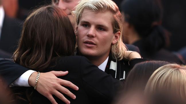 Jackson Warne hugs family and friends during the state memorial service for his father, Shane. Picture: Getty Images