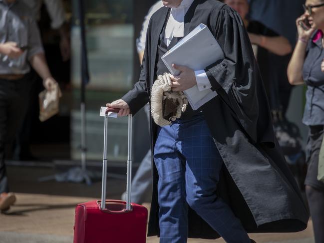 A barrister carries documents and a wig at the Supreme Court in Brisbane, Tuesday, October 29, 2019. (AAP Image/Glenn Hunt) NO ARCHIVING