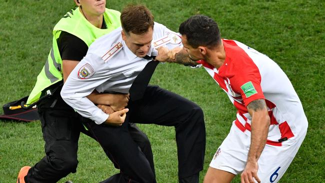 Security and Croatian defender Dejan Lovren attempt to restrain a protester. Picture: AFP