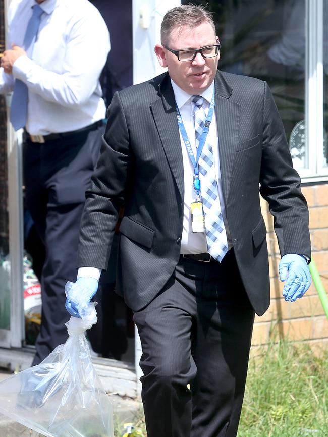 Detectives at the scene removing a lighter from front room of the house. PHOTO: Glenn Ferguson