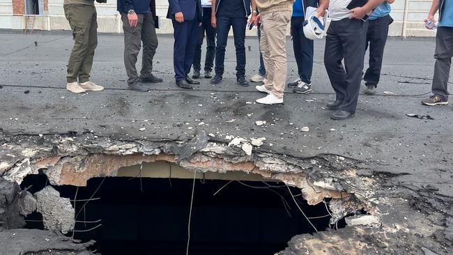 An IAEA team observe the damage caused by shelling on the roof of a building at the Zaporizhzhia Nuclear Power Plant that houses, among other items, fresh nuclear fuel and the solid radioactive waste storage facility.