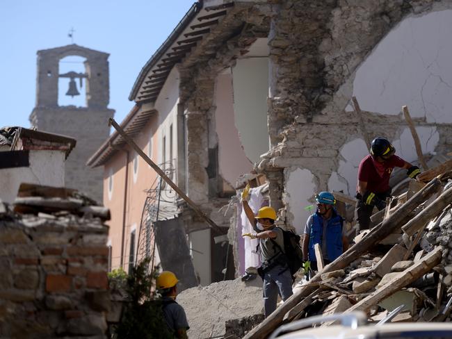 Volunteers work to move rubble and debris during search and rescue operations in Amatrice. Picture: AFP