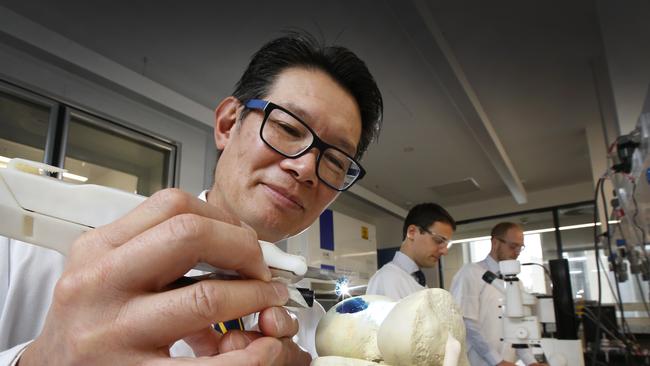 St Vincent’s Hospital orthopedic surgeon Prof Peter Choong practises using a 3D pen on a model of a knee joint with medical students Domagoj Vodanovic and Benjamin Murphy. Picture: David Caird