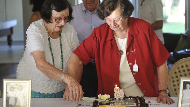 Emily (red) and Mary Betteridge celebrate their 80th birthday surrounded by friends on their 80th birthday. Picture: Marc Stapelberg.