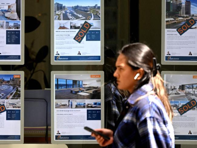 People walk past a real estate agent's window in Melbourne on March 7, 2023, as the Reserve Bank of Australia (RBA) raisesÂ interest rates for the 10th consecutive meeting, taking the cash rate target to 3.6 per cent. (Photo by William WEST / AFP)