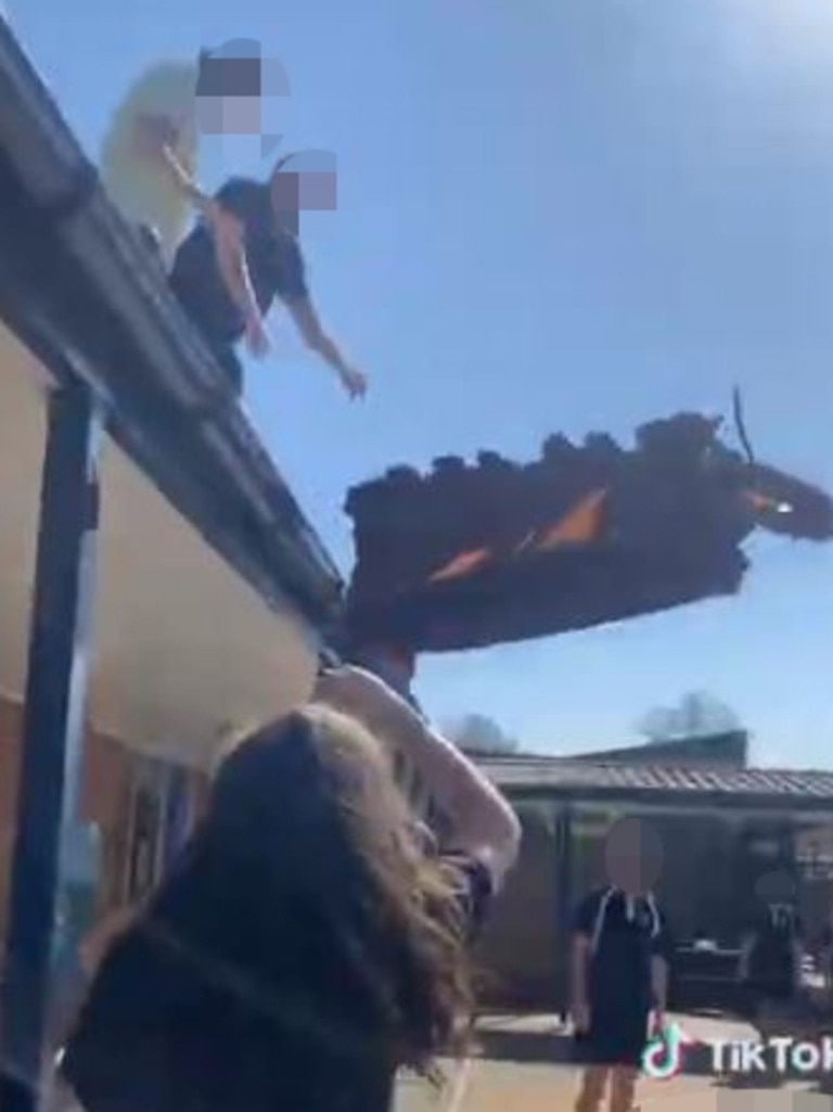 A couch is thrown from the roof of a NSW school.