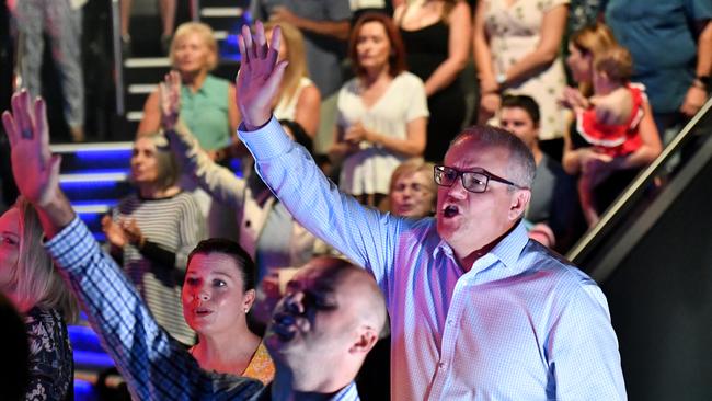 Prime Minister Scott Morrison and wife Jenny sing during an Easter Sunday service at his Horizon Church at Sutherland in Sydney.