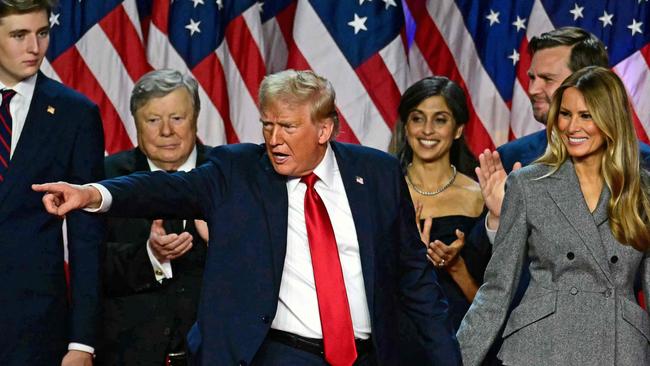 Donald Trump gestures at supporters as he holds hands with Melania Trump on election night in Florida. Picture: AFP