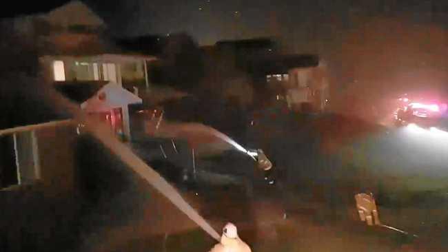 Firefighters hose down a line of houses in Angourie as fire embers shower down from an encroaching fire front on the night of Monday, 9th September, 2019. Picture: NSW RFS