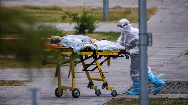 A medic escorts a woman into a hospital where patients with Covid-19 are being treated in the settlement of Kommunarka outside Moscow. Picture: AFP