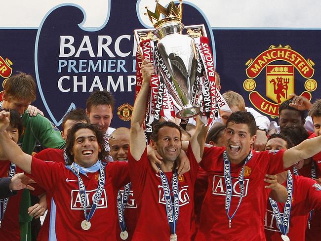 Winners are grinners ... Manchester United's, Ryan Giggs, centre, lifts the trophy as his team celebrate winning the English Premier League.