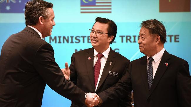 Malaysia's Transport Minister Liow Tiong Lai (C), Australia's Minister for Infrastructure and Transport Darren Chester (L) and Chinese Minister of Transport Yang Chuantang (R) shake hands after a joint press conference of the Ministerial Tripartite Meeting on the search for missing Malaysia Airlines flight MH370 at the Malaysian federal administrative centre in Putrajaya, outside Kuala Lumpur on June 22, 2016. Hopes of finding flight MH370's final resting place are "fading", and the three-nation search will be suspended if nothing is found in the suspected crash zone, Malaysia, Australia and China announced on July 22. / AFP PHOTO / MOHD RASFAN