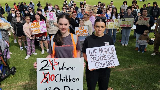 Grace Middleton and Stephanie Clarke stand in front of more than 100 residents who marched in the No More Violence Rally in Toowoomba's Queens Park, organised by volunteer group What Were You Wearing to advocate for more funding to stop domestic and family violence.