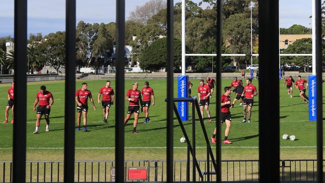 South Sydney players train behind a fence. Photo: AAP Image/Mark Evans