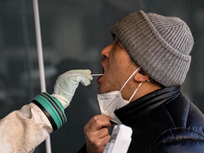 A health worker takes a swab sample from a man being tested for Covid-19 at a hospital in Beijing. Picture: AFP