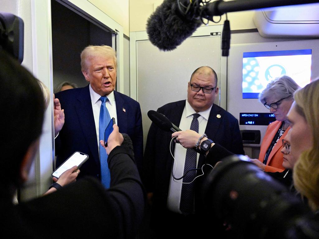 US President Donald Trump speaks with journalist, alongside White House Communications Director Steven Cheung, right, on board Air Force One en route from Miami, Florida, to the White House in Washington, DC on February 19. Picture: Roberto Schmidt/AFP