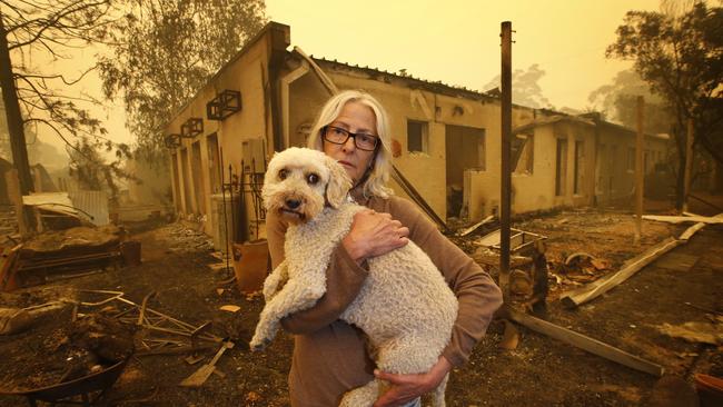 Jann Gilbert with her dog Ollie visits the site of her burnt out unit. Picture: David Caird