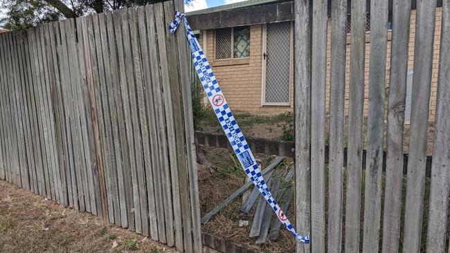 The back fence of Olive's unit has eight missing palings. Police tape is covering the gap. Picture: Alex Treacy