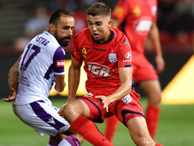 Adelaide United’s Nathan Konstandopoulos gets past Perth Glory’s Diego Castro on Friday night. Picture: AAP 