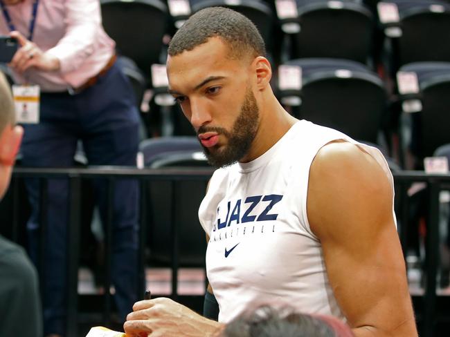 (FILES) In this file photo taken on December 04, 2019 Utah Jazz center Rudy Gobert signs autographs after warm ups, before a NBA game against Los Angeles Lakers in Salt Lake City, Utah. - The NBA will suspend play starting on Thursday after a Utah Jazz player preliminarily tested positive for the new coronavirus, the league said March 11, 2020. The test result was reported shortly before Utah's game against the Thunder in Oklahoma City was to begin, and that game was abruptly postponed. The NBA did not name the player who had tested positive, but several US media outlets reported it was French defensive standout Rudy Gobert, who was listed first as questionable for the game and then as out with illness. (Photo by GEORGE FREY / AFP)