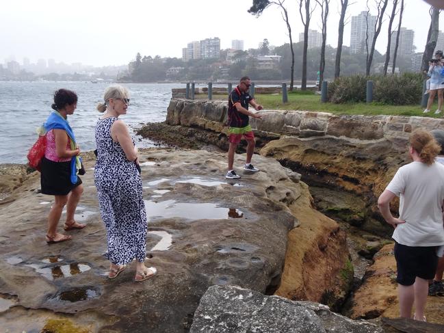 A Tribal Warrior tour guide points out natural fish traps on Sydney Harbour.