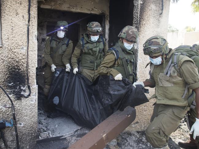 Israeli soldiers remove the body of civilians killed days earlier in an attack by Palestinian militants in Kfar Aza, Israel. Picture: Getty Images