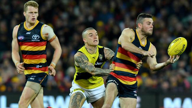 Brad Crouch fires out a handpass in front of Tiger Dustin Martin, on his way to a career-high 43 disposals in Round 13.