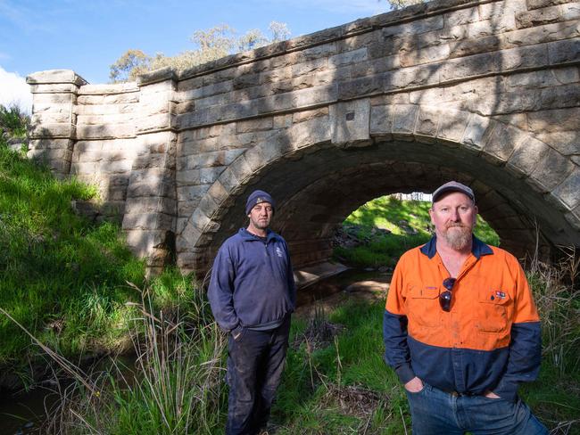 Local residents Gerard Hamill, and. Steve Tobin at the bridge they say the beams cannot travel over on the Hume Freeway. HUNDREDS of giant concrete segments built to line the walls of the West Gate Tunnel will be trucked at a snails pace through regional towns and back roads because the government's rail plan for the project does not work.  Picture: Jason Edwards