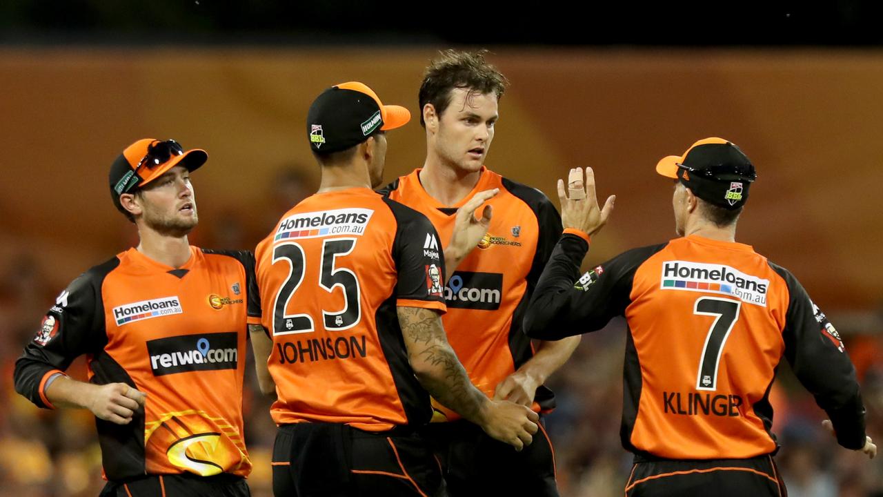 Scorchers players congratulate Matthew Kelly (centre).