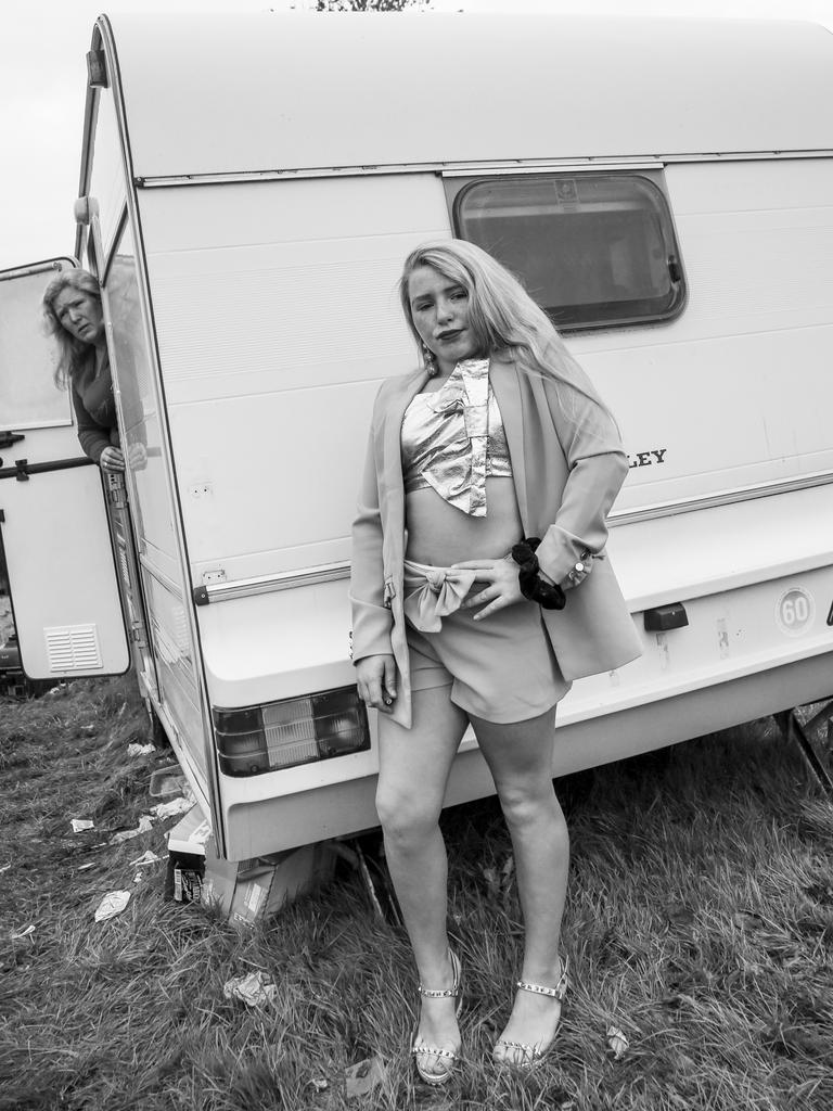 A girl poses outside a caravan as a woman watches. Picture: Jamie Johnson