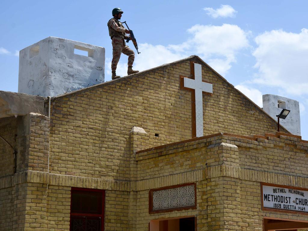 A Pakistani soldier stands guard on the roof of a Methodist Church during the Easter service after a series of eight bomb blasts ripped through hotels and churches. Picture: AFP