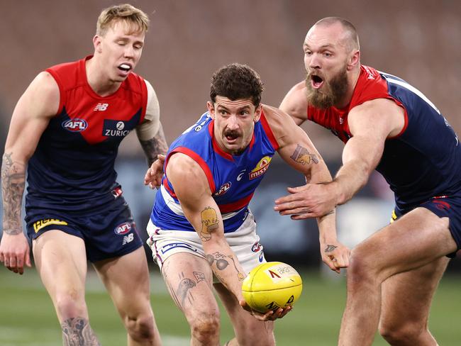 AFL Round 19.  Melbourne v Western Bulldogs at the MCG,  Melbourne. 24/07/2021.   Bulldog Tom Liberatore clears by Han in front of Max Gawn of the Demons    .  Pic: Michael Klein